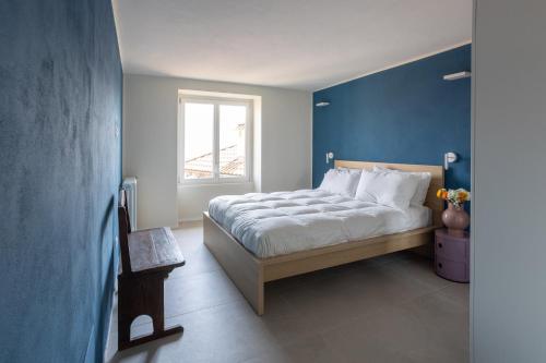 a bedroom with a bed with blue walls and a window at Antica Villa Branca by Lago Maggiore Rentals in Cannobio