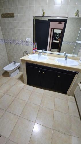 a bathroom with two sinks and a toilet and a mirror at Villa lux AP2 in Saïdia