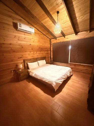 a bedroom with a bed in a wooden room at اكواخ بيلا 2 in Taif