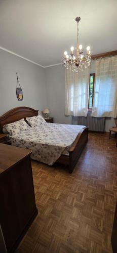 a bedroom with a bed and a chandelier at Respiro di montagna by Lago Maggiore Rentals in Vigino