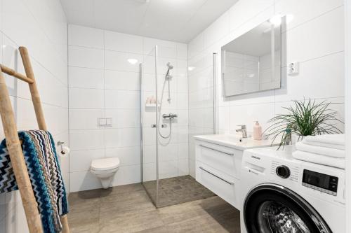 a bathroom with a shower and a toilet and a sink at Voy Stays Molde sentrum in Molde