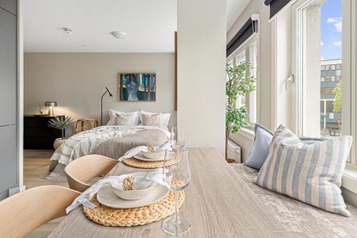 a living room with a bed and a table with dishes on it at Voy Stays Molde sentrum in Molde