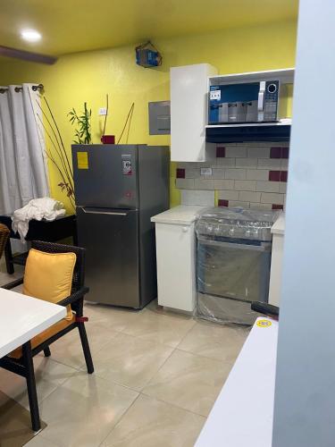 a kitchen with a refrigerator and a table and chairs at Attre guesthouse in Basseterre