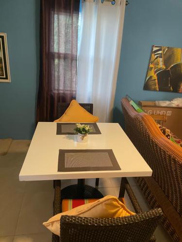 a white table with a vase of flowers on it at Attre guesthouse in Basseterre