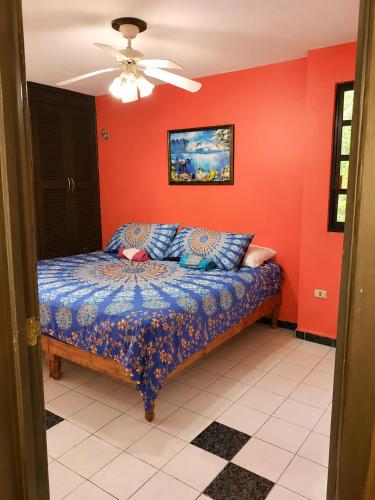 a bedroom with a bed with red walls and a ceiling at Villa Bonita Torre 16 in Cozumel