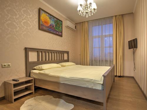 um quarto com uma cama, um lustre e uma janela em Apartment Kutuzoff Metro Kievskaya em Moscou