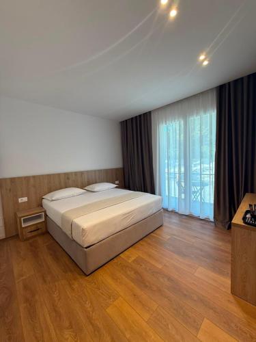 a bedroom with a bed and a large window at Villa SkyWay in Krujë