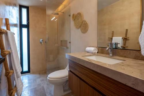 a bathroom with a sink and a toilet and a shower at BT Homes - Tankah Bay Tulum - Exclusivos apartamentos con piscina a metros del mar in Tancah