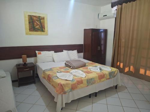 a bedroom with a bed with a suitcase on it at Girassol praia hotel in Valença