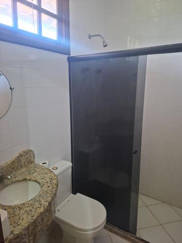 a bathroom with a toilet and a sink and a shower at Girassol praia hotel in Valença