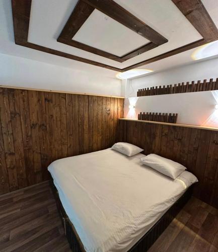 ein großes Bett in einem holzgetäfelten Zimmer in der Unterkunft Arida farm in Bischarri