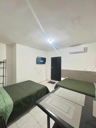 a room with two beds and a tv on the wall at Depas Expo Estadio in Monterrey