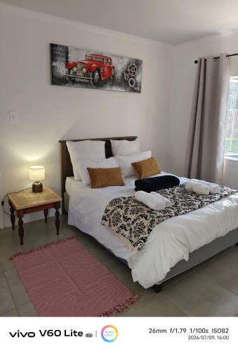 a bedroom with a large bed with a red car above it at Firehouse self-catering cottage 7 in Wellington