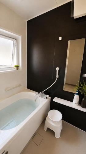 a bathroom with a white tub and a toilet at IWAKI Stay KAKUREGI in Hirosaki