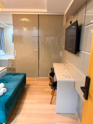 a room with a bed and a desk and a tv at Pousada Lumiera House in Foz do Iguaçu