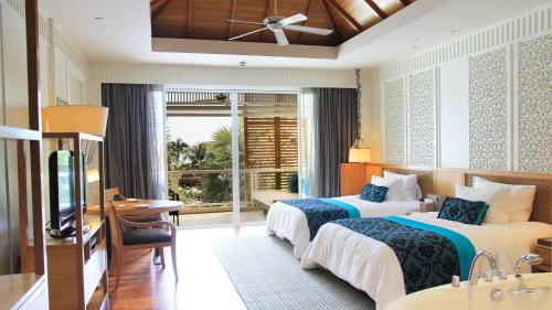 a hotel room with two beds and a television at InterContinental Hua Hin Resort by IHG in Hua Hin
