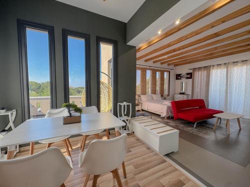 a living room with a table and a red chair at Villa Velvet Chios in Chios