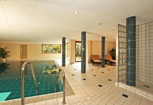 a house with a swimming pool and a living room at Hotel Adler in Aalen