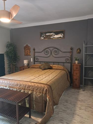 a bedroom with a large bed and a wooden bench at Casa La Tapita in Marbella