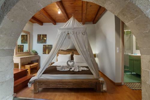 a bedroom with a bed with a canopy at Villa Epavlis in Plaka