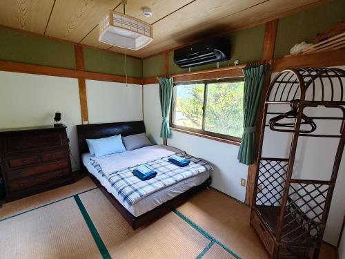 a bedroom with a bed and a bunk bed at Ikada in Amami