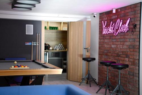 a kitchen with a pool table and a bar with stools at Cobalt Apartments in Mikołajki