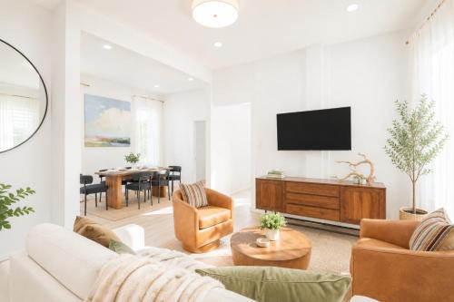 a living room with a couch and a tv at The Harper Loft near Manhattan with NYC skyline view in Hoboken