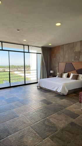 a bedroom with a bed and a large window at Casa Diamante Viñedos in Ezequiel Montes