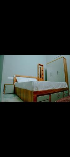 a bedroom with a large bed with a wooden frame at Corniche inn river view villa 2 BHK in Kāsaragod