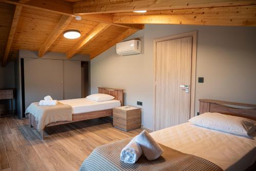 a bedroom with two beds and a wooden ceiling at Aifantis Villa 1 in Póndi