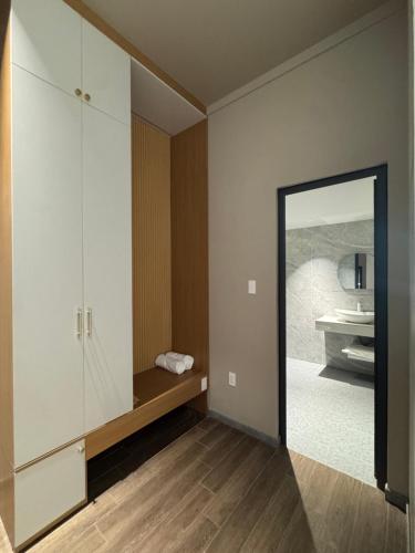 a room with a mirror and a bathroom with a sink at Mia Hotel in Ga Trảng Bôm