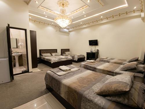 a room with four beds and a chandelier at Hotel Buston in Chkalovsk