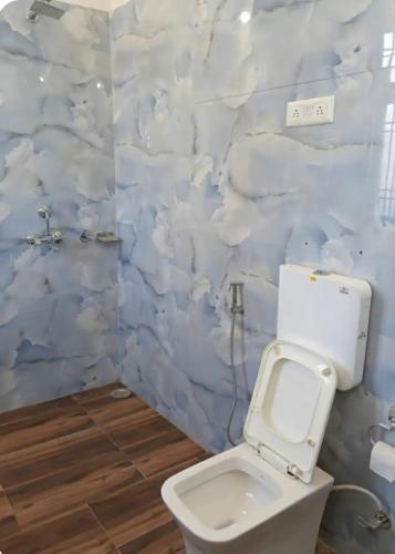 a bathroom with a toilet and a wall covered in clouds at Mystic Paradise in Jaipur