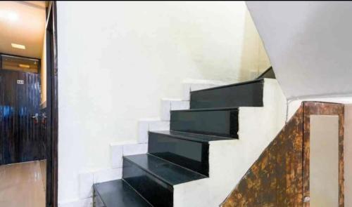 a staircase in a building with black shelves at Hotel shree in Indore