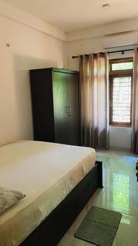 a bedroom with a bed and a green cabinet at Calm bay in Minneriya