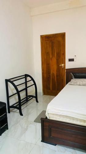 a bedroom with a bed and a wooden door at Calm bay in Minneriya