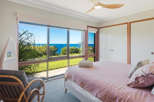 a bedroom with a bed and a view of the ocean at Viewpoint in Tathra