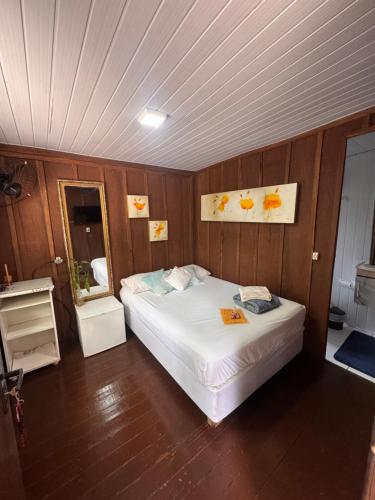 a bedroom with a bed and a mirror in it at Recanto do Sol I in Ilha do Mel