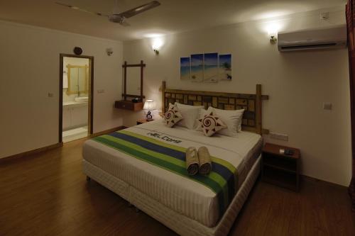a bedroom with a large bed with shoes on it at Shallow Lagoon Rasdhoo in Rasdu