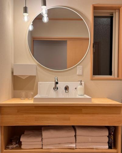 a bathroom with a sink and a mirror at Yamamori House in Hakuba