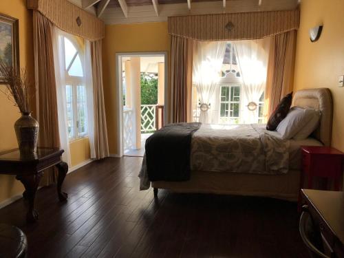 um quarto com uma cama, duas janelas e uma porta em Penthouse On The Ridge em Ocho Rios