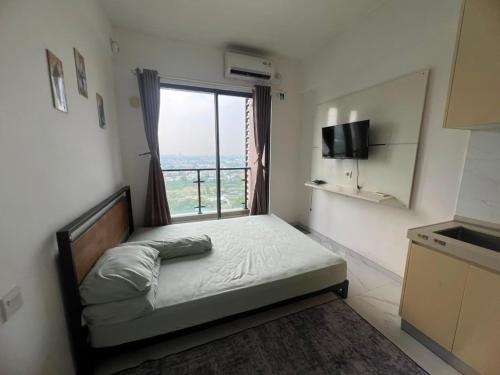 a small bedroom with a bed and a window at Sky House BSD By Micky Studio in Cilenggang
