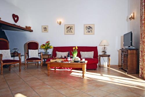 a living room with a red couch and a table at Domaine Saint Ferreol in Nizas