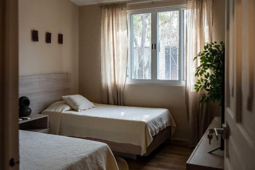a room with two beds and a window at Casa MarEscondido in Puerto Escondido