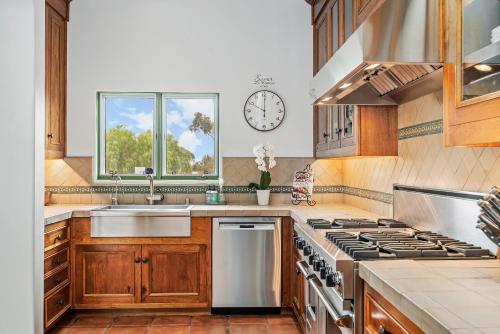 a kitchen with a sink and a clock on the wall at La Vida Riviera in Santa Barbara