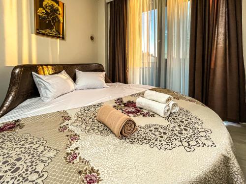 a bed with two pillows and towels on it at Hotel Nika in Batumi