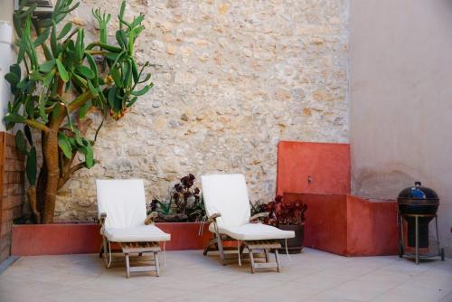 a group of three chairs sitting next to a wall at Au coeur de Leucate in Leucate