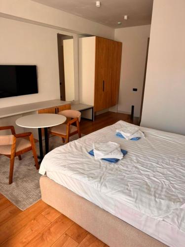 a bedroom with a bed and a table and a table and chairs at Ilshat mini hotel in Cholpon-Ata
