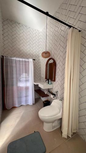 a bathroom with a toilet and a shower curtain at Arrum Villa in Ungasan