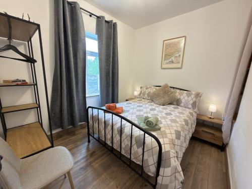 a bedroom with a bed and a chair and a window at The Old Post Office Cottage in Castlebar